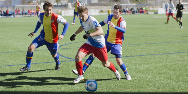 Oriol i Cristian surten al pas d’un jugador de l’Avià per a que no s’acosti a l’àrea.