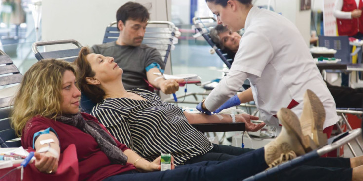 Diverses persones participen en una campanya de donacions de sang.