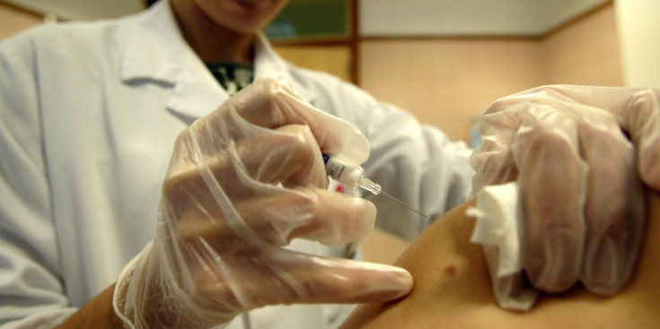 Una infermera subministra una vacuna a un pacient.