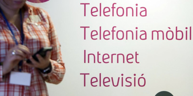 Una usuària davant d’un cartell d’Andorra Telecom.