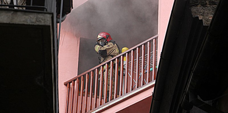 Un dels bombers en plena actuació al pis on es va originar l’incendi, ahir.