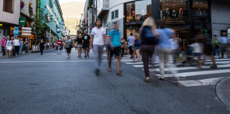 Uns vianants caminen en l’encreuament del carrer de la Unió, que delimita les avingudes Carlemany i Meritxell.