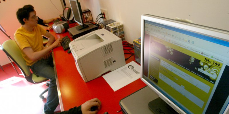 Uns joves miren Internet en un ordinador.