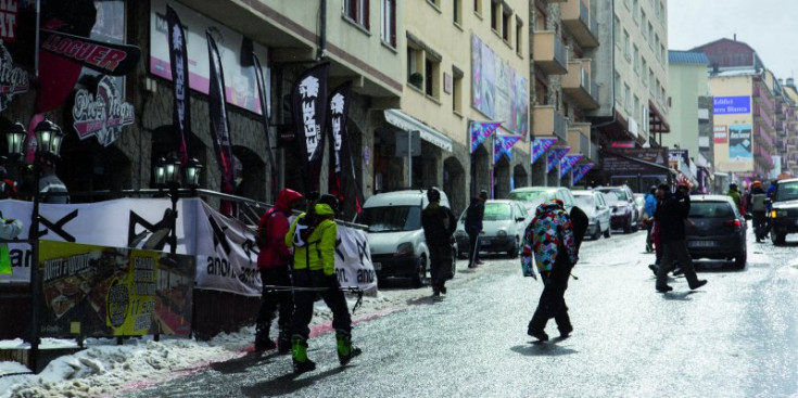 Un joves a l’hivern van amb l’equipació d’esquí al centre del Pas de la Casa.