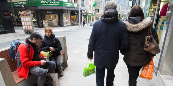 Dos turistes amb bosses de plàstic a Escalds-Engordany.