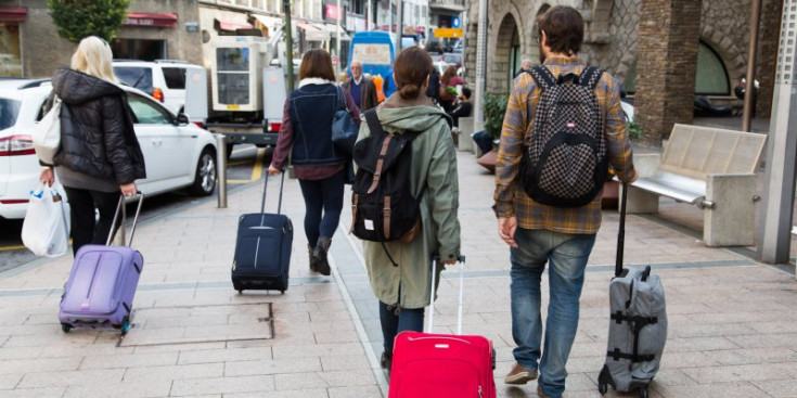Turistes passegen per Andorra amb maletes.