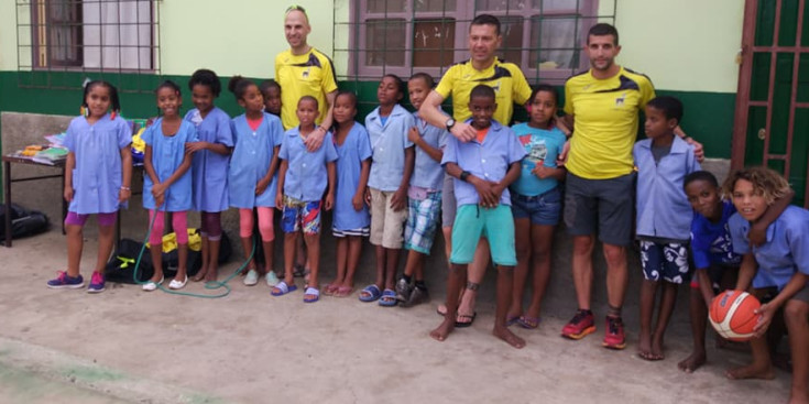 Amb la samarreta groga i d’esquerra a dreta, Berenguer, Repiso i Castellet amb els nens de l’escola de Palmeira on van donar el material.
