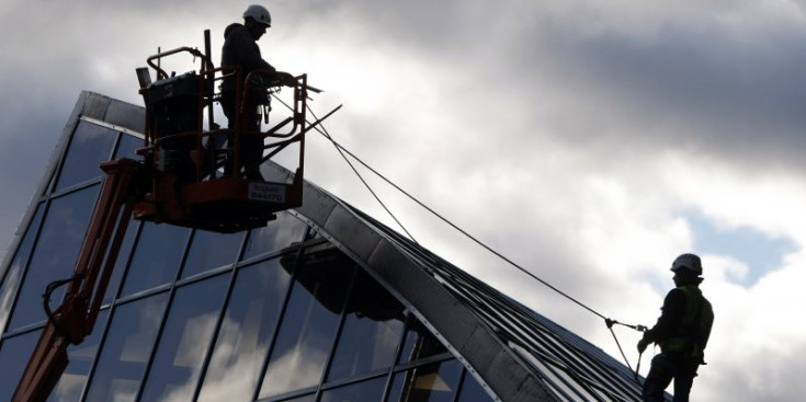 Uns operaris treballen en l’estructura exterior de l’edifici de Caldea, en les actuacions habituals de neteja de vidres en treball en alçada.