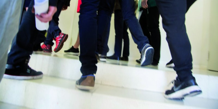 Estudiants adolescents caminant entre classes en un institut.