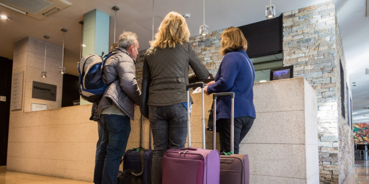 Turistes a la recepció d’un hotel mentre fan el procés de ‘check-in’.