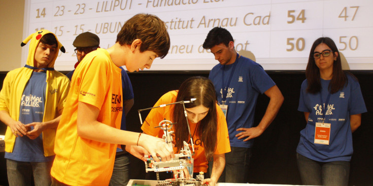 Un equip de joves treballen en els seus robots de la Lego League.