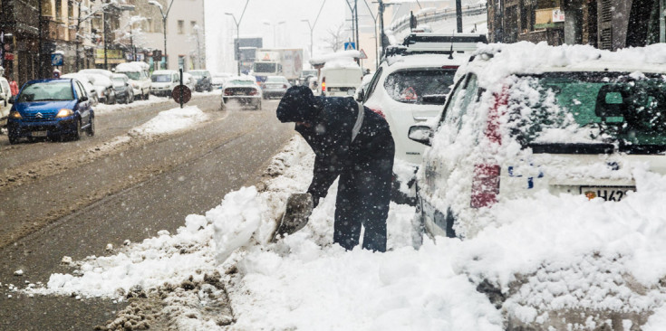 Un ciutadà treu neu de la via pública, aquest matí a la Massana.