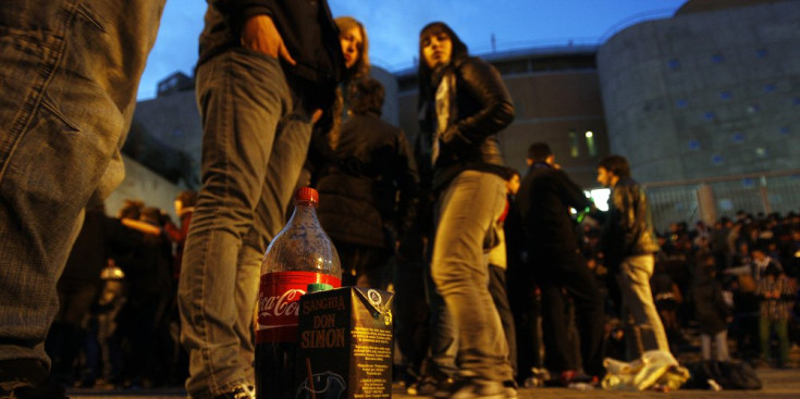Uns adolescents beuen al carrer.