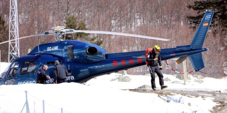 Un helicòpter dels Mossos d'Esquadra i diverses persones de l'equip de rescat a la zona de la Vall de Conangles.