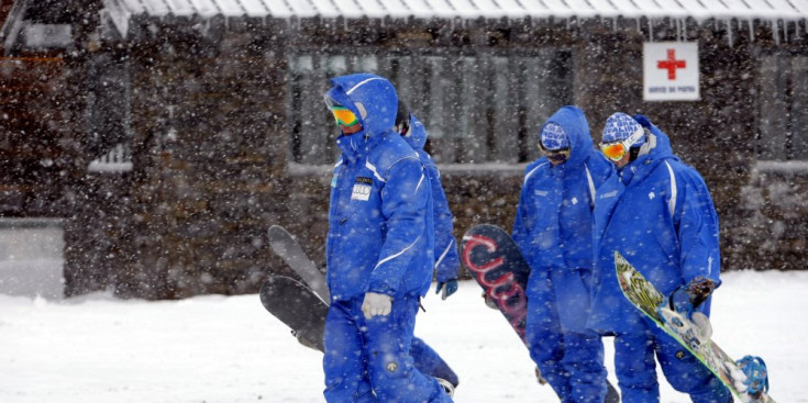 Monitors d’Snow de Grandvalira caminen mentre neva amb intensitat.