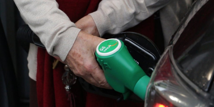 Usuari d'una benzinera carregant el dipòsit del seu vehicle.