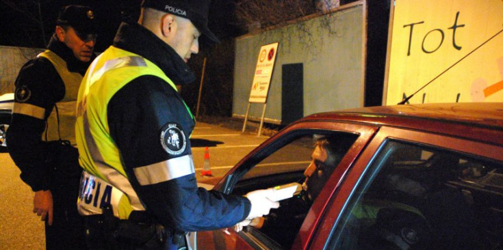 Uns agents de policia realitzen controls d'alcoholèmia als conductors.