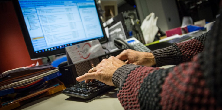 Un empleat treballa en un ordinador d'una oficina.