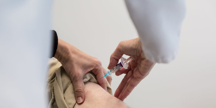 Una infermera administra una vacuna a un pacient.