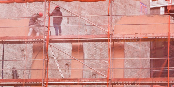 Dos persones treballen en un edifici en construcció.
