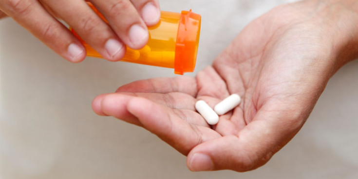 Una persona aboca a la seva mà un parell de pastilles.