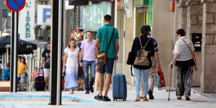 Turistes amb maletes caminant per l'avinguda Meritxell aquest mes d'agost.