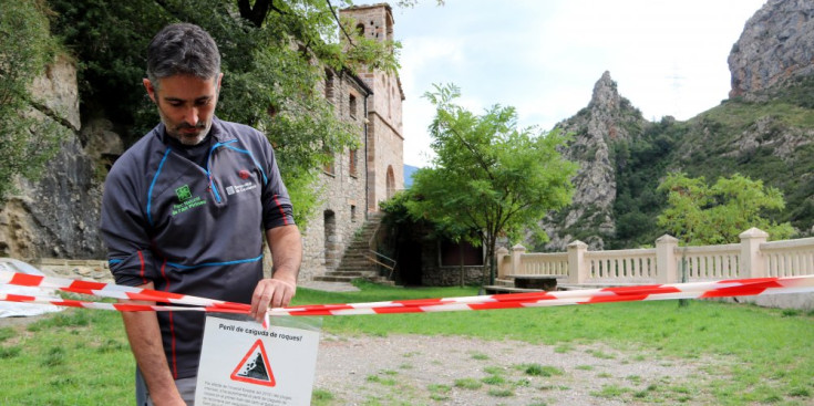 El director del Parc Natural de l'Alt Pirineu mostra el rètol que indica els motius del tancament de l'accés al santuari d'Arboló.