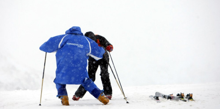 Un monitor ensenya a esquiar a un turista.