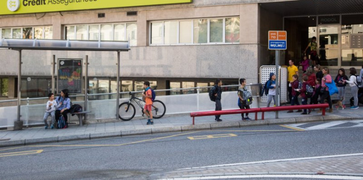 Un grup de joves i adults a prop d’una parada d’autobús a Escaldes-Engordany.