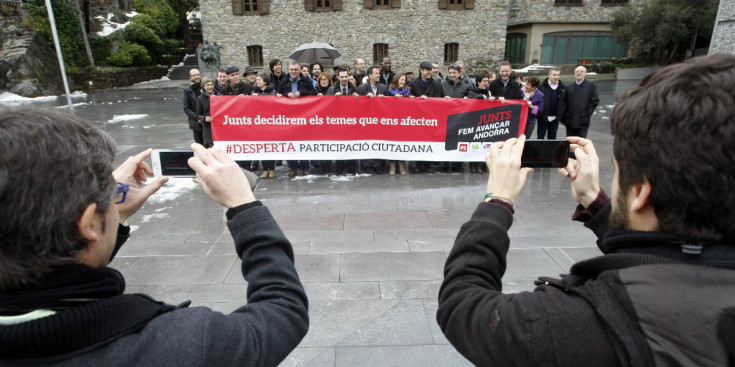 Els membres de la coalició progressista amb una pancarta davant de la Casa de la Vall d’Andorra la Vella, ahir.
