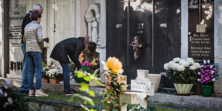 Varies persones deixen flors al cementiri vell d’Andorra la Vella.