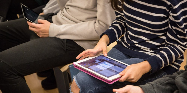 Un grup d’adolescents consulta diferents xarxes socials des de les seves tauletes.