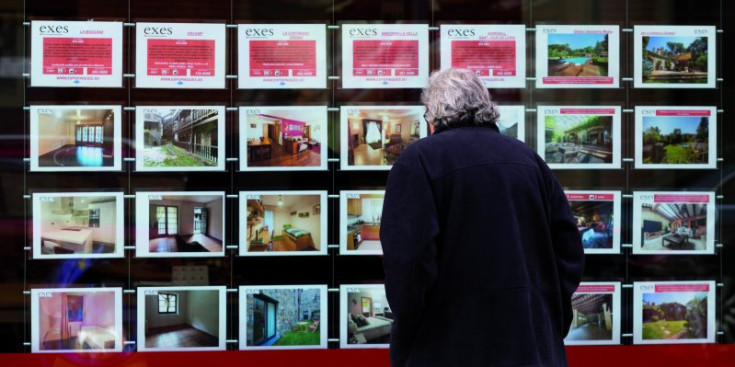 Un home mira els anuncis d'una immobiliària.
