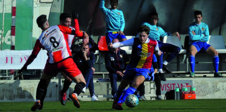 El jugador de l’FC Andorra, Jordi Betriu, supera a Ivan García al Camp Municipal de Viladecans, ahir.