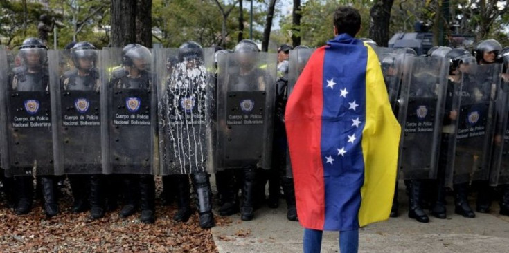 Un manifestant davant la Policia Nacional Bolivariana.