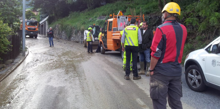 Autoritats netejant el tram de carretera afectat per l'esllavissada.