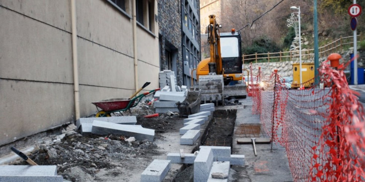 Una excavadora treballa en les obres fetes al carrer de les Boïgues.