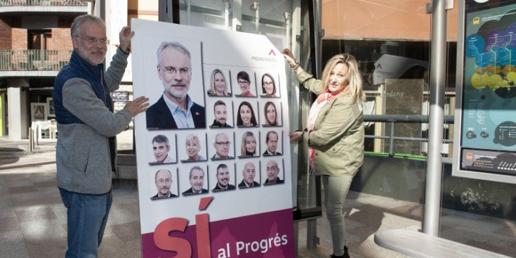 El candidat nacional pels progressistes, Josep Roig, i la número dos, Sandra Cano, pengen un cartell a Escaldes-Engordany, ahir.