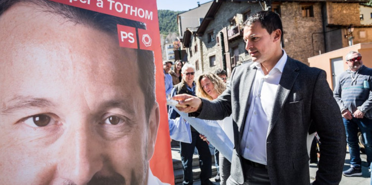 El liberal Jordi Gallardo penja un cartell al costat del ja enganxat de la candidatura de Pere López.