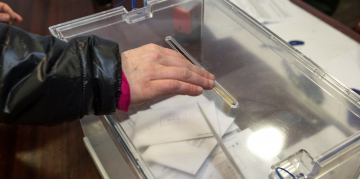 Un elector diposita el seu vot a una urna.