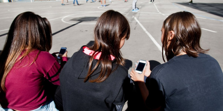Unes noies amb els seus telèfons mòbils al pati d’una escola de la parròquia d’Andorra la Vella.