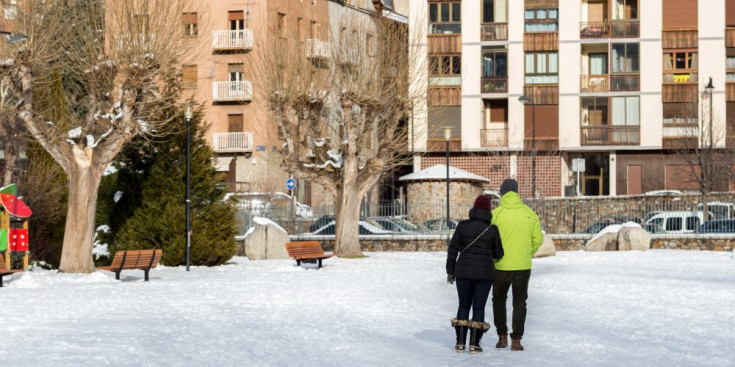Dues persones passegen pel Prat Gran completament nevat l’hivern passat.