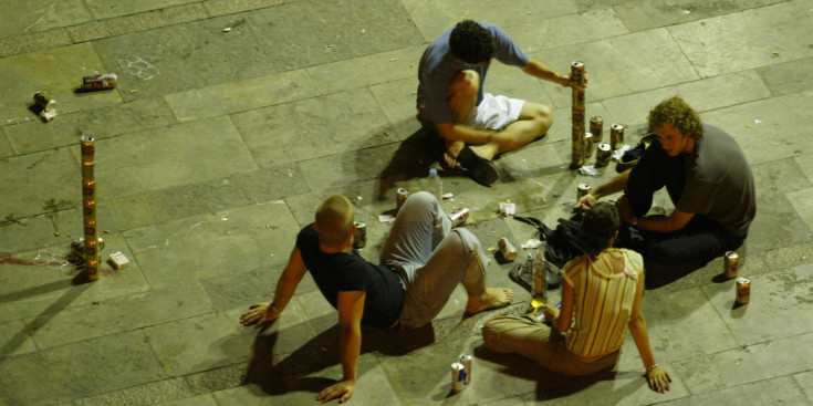 Quatre joves beuen al carrer en una festa major