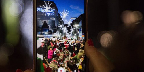 Un persona grava amb el seu telèfon una desfilada nadalenca.