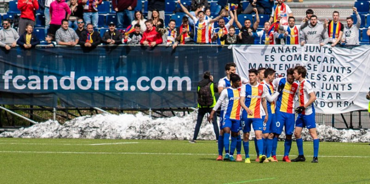 Els jugadors de l’FC Andorra celebren el segon gol de Víctor Casadesús mentre la grada d’animació explota d’alegria.