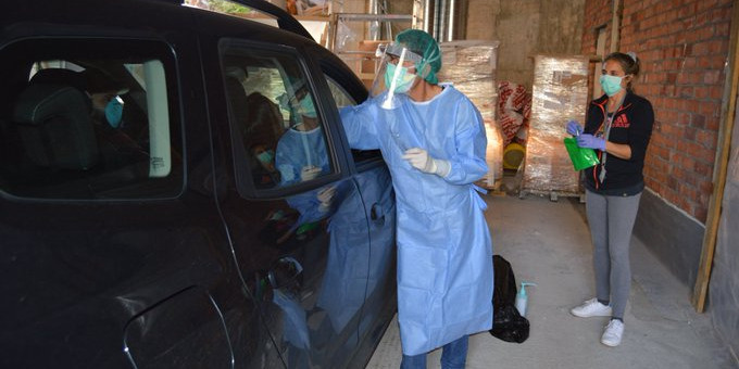 Un professional realitza una prova de PCR a un pacient des del cotxe.
