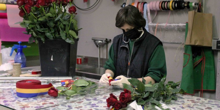 Una florista treballa preprant els rams de roses per Sant Jordi.