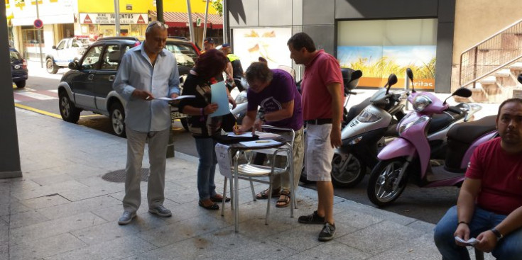 Una ciutadana respon a la consulta amb Joan Seguí i Cristian Asensio a la dreta i Joseba Imanol, a l’esquerra.