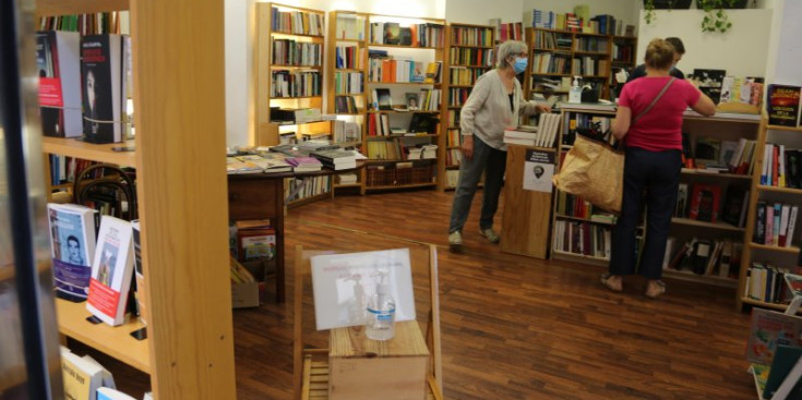 Una clienta compra un llibre a La Puça.