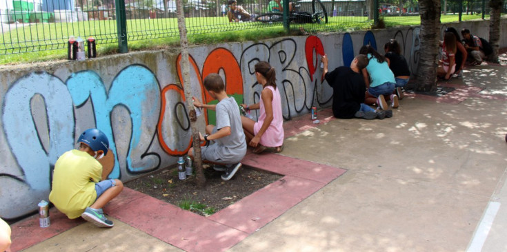 Un grup de nois i noies pinten el missatge a la paret del parc Central, ahir a la tarda.